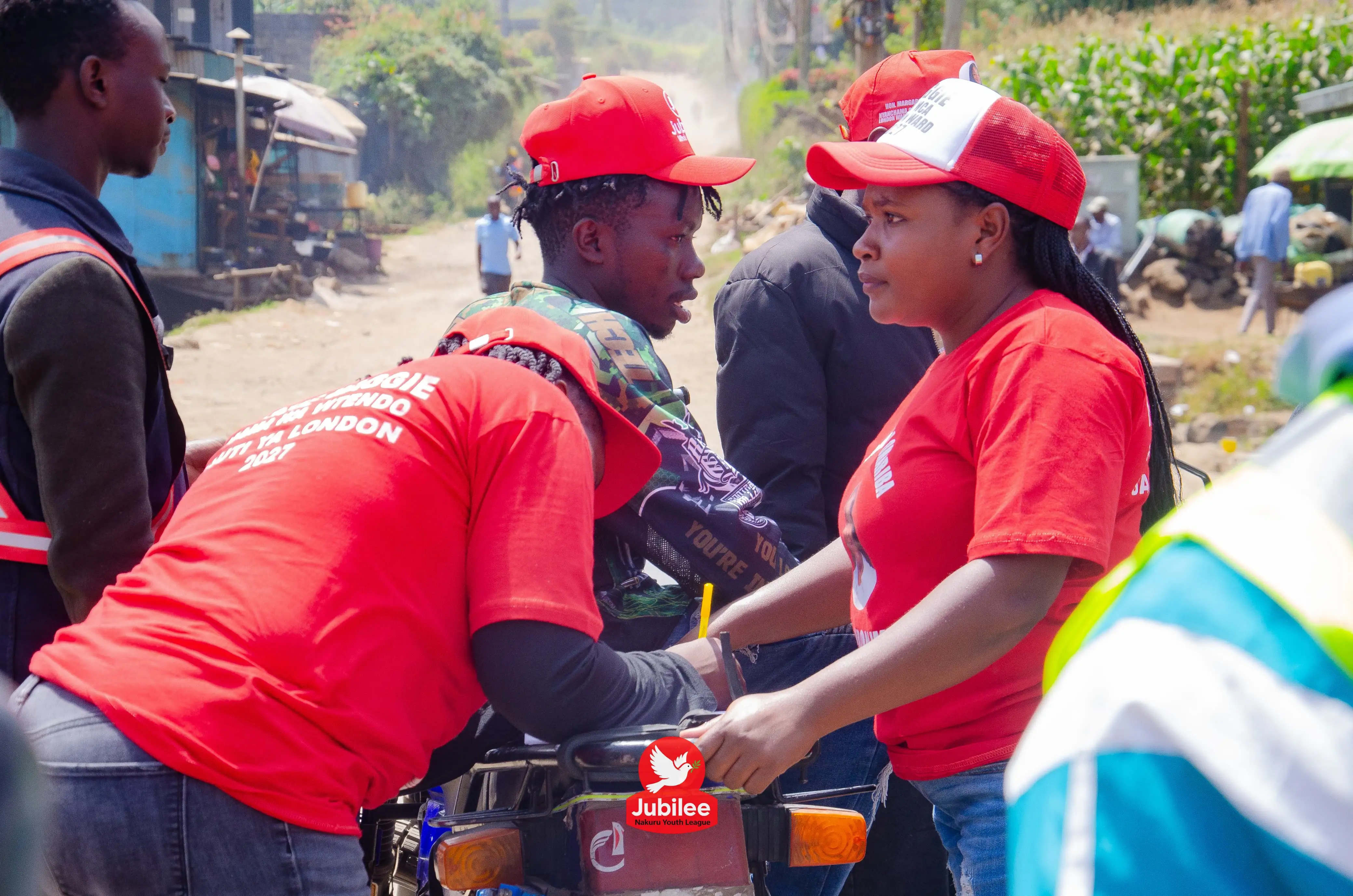 Young woman in a red tee chatting with a boda rider