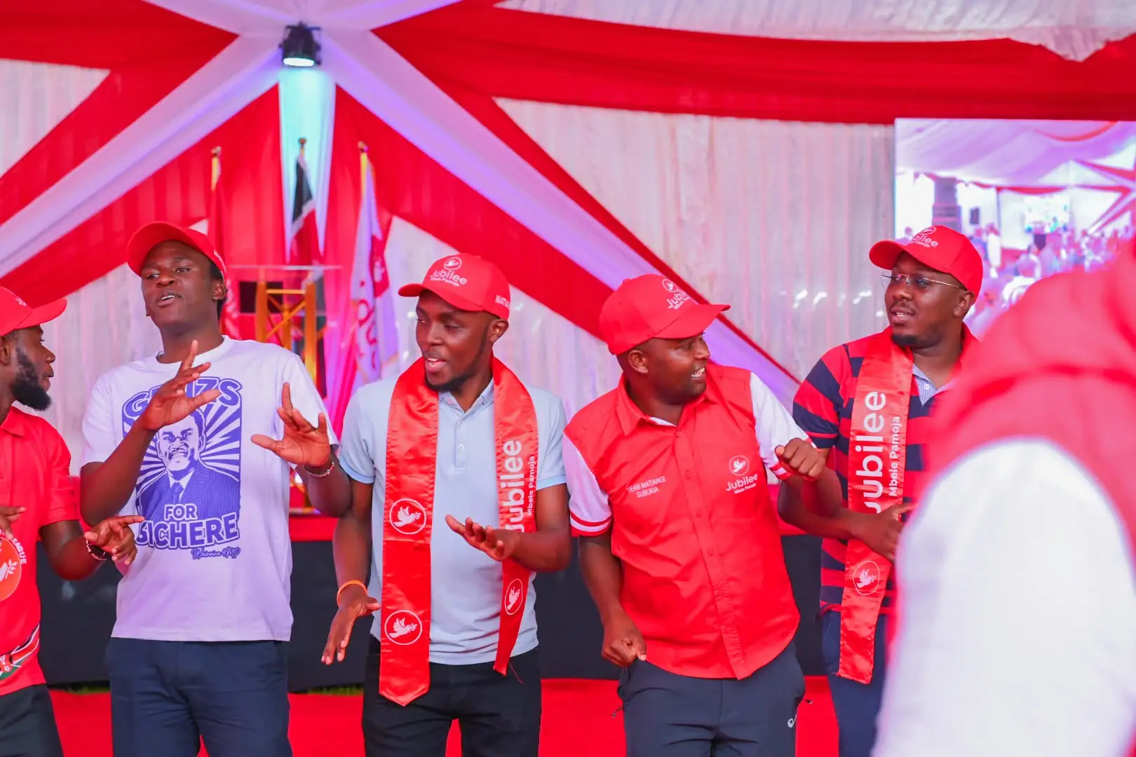 Young men in red on stage leading a session